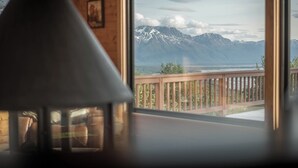 Een kamer met uitzicht op bergen en een balkon.