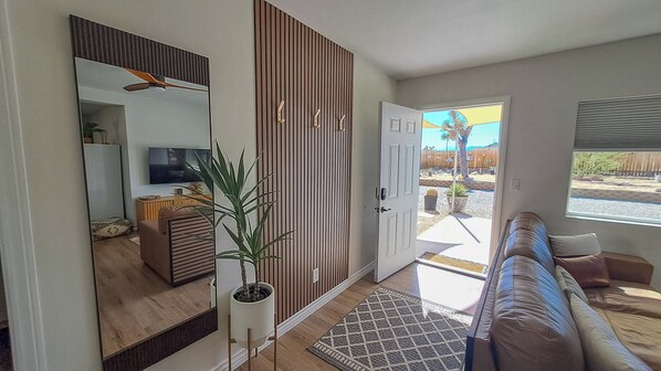 A living room with a sofa, a television, and a potted plant. - Welcome to Joshua Tree Getaway – Your Desert Oasis Awaits (Joshua Tree)