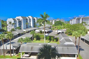 A resort with multiple-story buildings, covered parking, and palm trees.