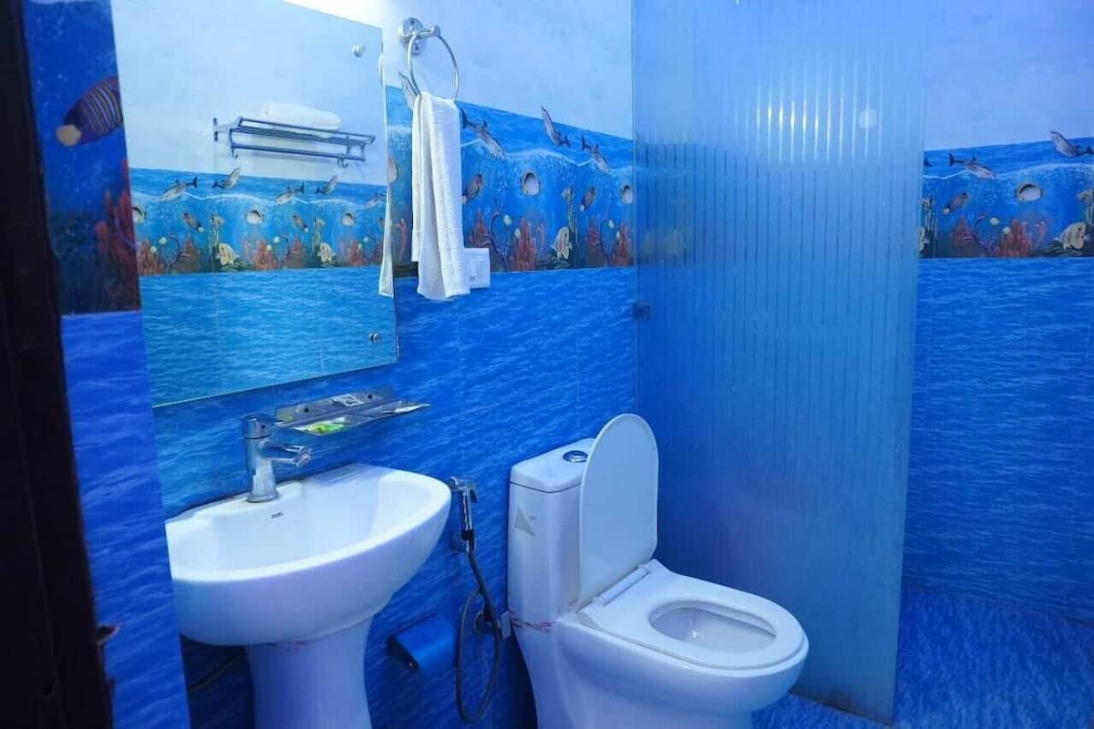 A bathroom with a sink, toilet, and a mirror.