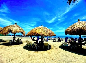 Relax in comfort under shaded lounge chairs, steps from the ocean.