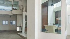 A spacious, multi-level office area with a reception desk, a staircase, and a view of the outside. - Townhouse Oak Ancol (Jakarta)