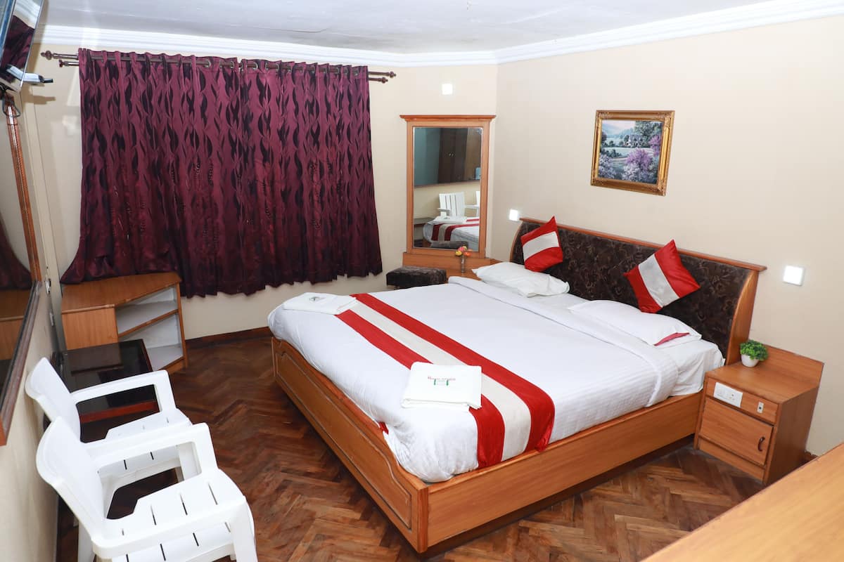 A neatly arranged bedroom with a bed, bedside table, chair, and a mirror.