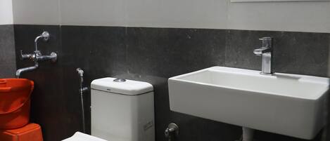 A bathroom with a toilet, sink, and shower.