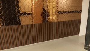 A room with a wooden slatted partition and a reflective surface. - Hotel Indriya (Greater Noida)