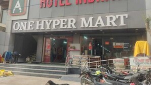 A building with a sign for Hotel Indriya and One Hyper Mart. - Hotel Indriya (Greater Noida)