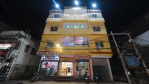 A multi-story building with various shops on the ground floor, including a sweets shop and a furniture store. - Kamala Hotel (Deoghar)