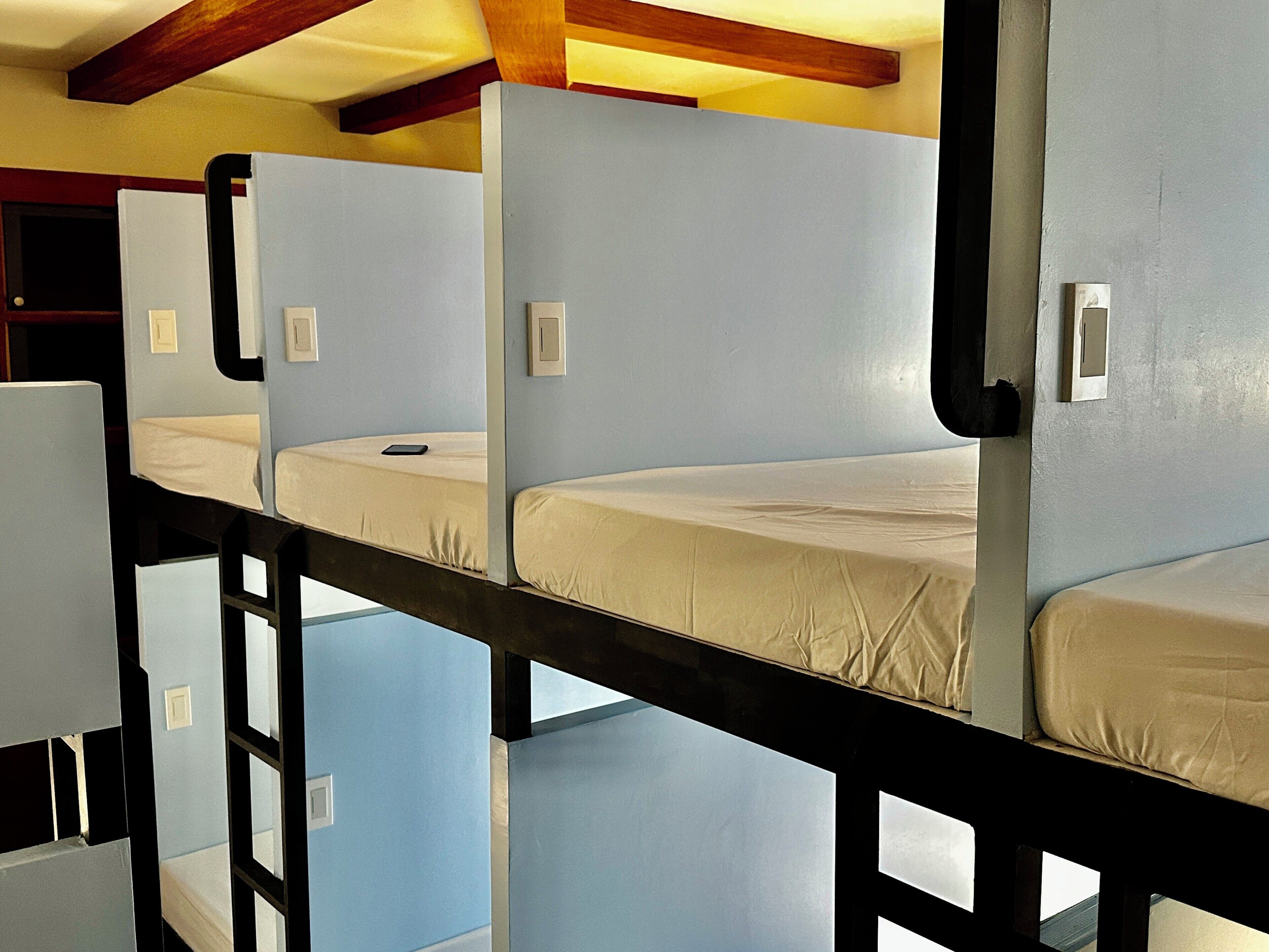 Ein Schlafzimmer mit Etagenbetten, Holzboden und hellblauen Wänden.