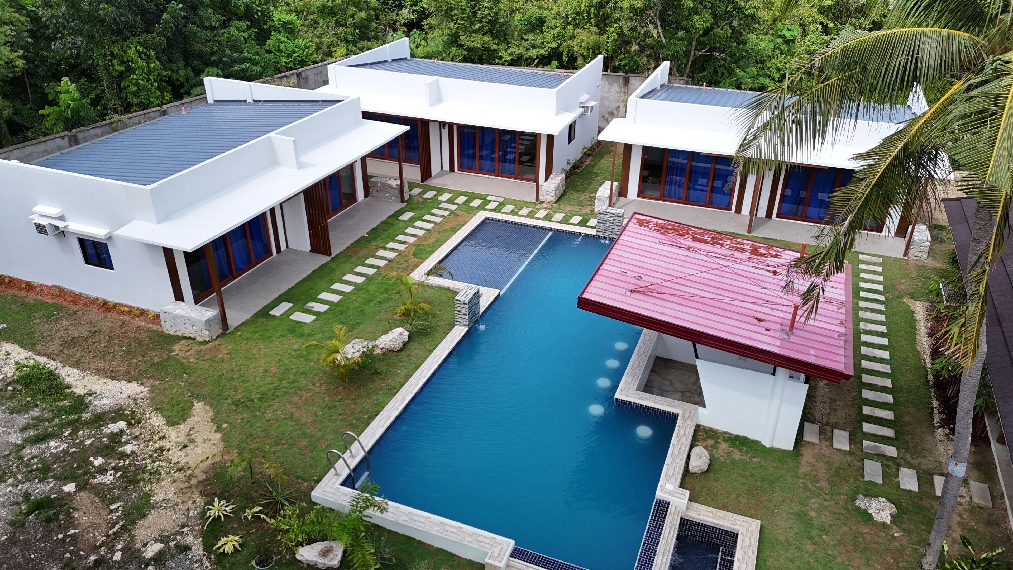A modern house with a swimming pool, solar panels, and a well-maintained garden.