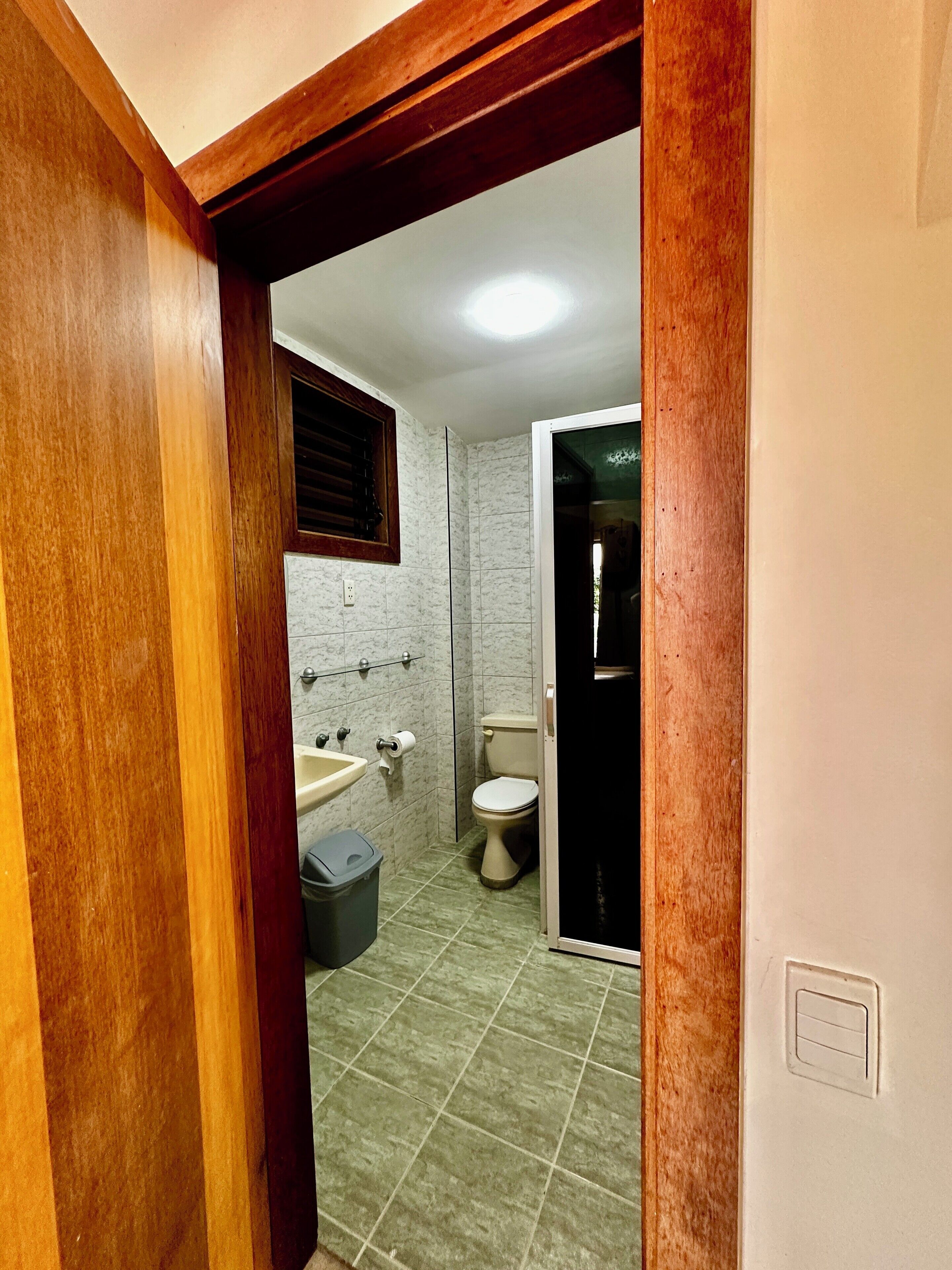 A bathroom with a toilet, sink, and shower area.