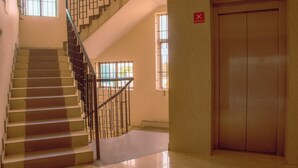 A staircase with a metal railing, a door marked with the number 3, and a window with a view of greenery. - Naksha Tree Hotels Kishore Inn - Koyambedu (Chennai)