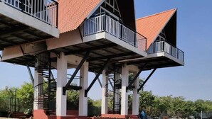 Un edificio con un diseño arquitectónico único que presenta plataformas elevadas y un patrón de cuadros en la base.