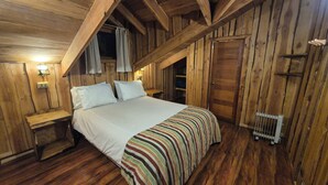 A wooden room with a bed, nightstands, and a radiator. - Neltume Lodge (Panguipulli)