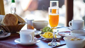 A breakfast setting with a variety of dishes, including scrambled eggs, toast, and orange juice. - Neltume Lodge (Panguipulli)