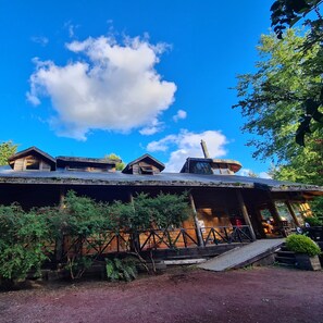 A rustic cabin-style building with a sloped roof and a chimney. - Neltume Lodge (Panguipulli)