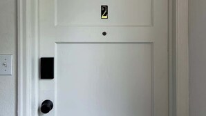 A white door with a small black intercom and a keyhole. - Spacious 2BR Apt in the Heart of Fargo (Fargo)