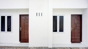 A building with two identical doors and windows, each with a small vent above the door.