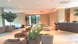 A modern hotel lobby with seating areas, a reception desk, and potted plants. - Viewpoint Khaoyai Hotel (Pak Chong)