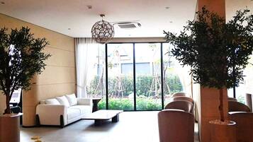Una sala de estar moderna con sofá, mesa de centro y plantas en macetas.