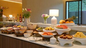 A buffet with various food items and a vase of flowers. - Viewpoint Khaoyai Hotel (Pak Chong)