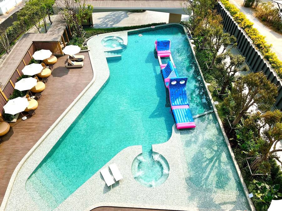 Una piscina al aire libre, sombrillas, tumbonas