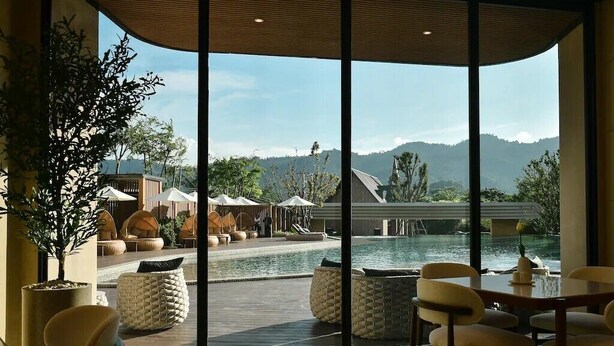 A modern hotel room with large windows, a pool, and outdoor seating. - Viewpoint Khaoyai Hotel (Pak Chong)