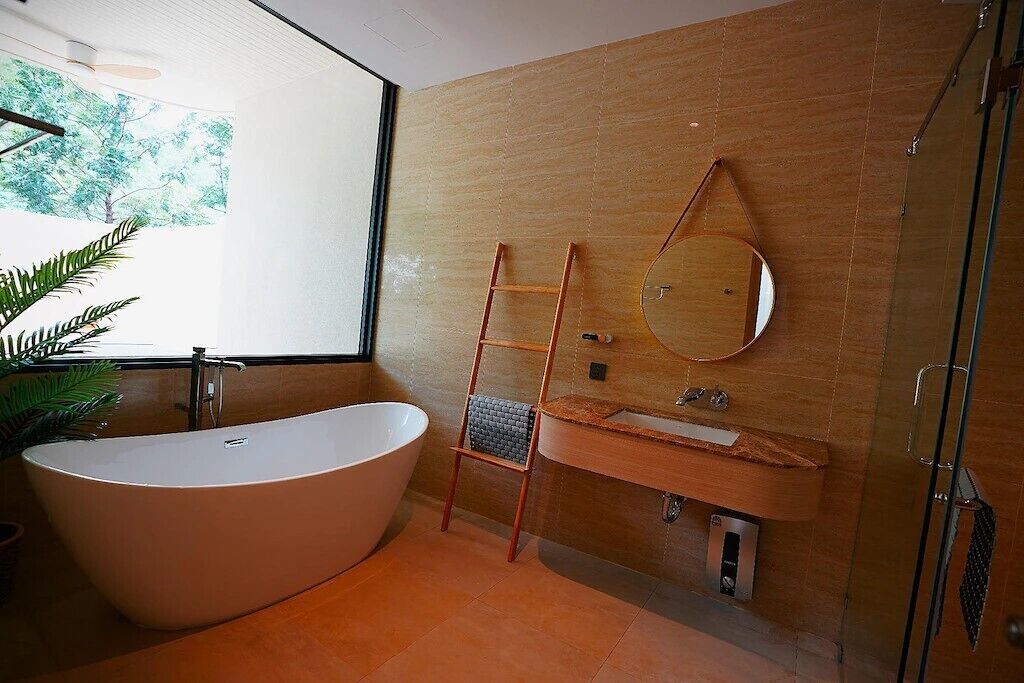 A modern bathroom with a freestanding bathtub, a wooden vanity, and a large mirror.