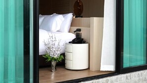 A bedroom with a bed, bedside table, and a small potted plant. - Viewpoint Khaoyai Hotel (Pak Chong)