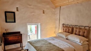 Un dormitorio con cama, cómoda y ventana.
