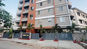 A multi-story residential building with a modern design, featuring balconies and a gated entrance. - Mighter Crest Studio Apartment (Nashik)