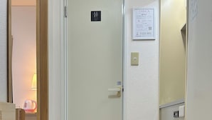 A hotel entrance with a door, a sign indicating a toilet, a small mat, and a pair of slippers on the floor. - Cheap, 2-minute walk from the nearest station, 5 minutes to Namba by train, direct connection to Kansai International Airport, excellent access 【101 】. (大阪市)