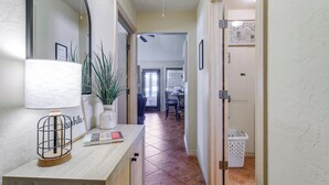 A hallway with a lamp, a potted plant, a mirror, and a door leading to a dining area. - 1/2 Mi to Lake Lawtonka: Mtn-View Haven! (Medicine Park)