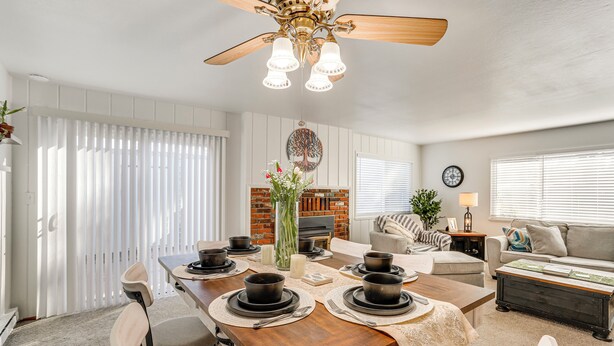 Comedor con mesa de madera dispuesta para cuatro personas, rodeada de sillas.