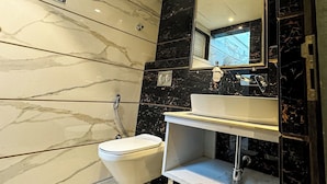 A bathroom with a toilet, sink, and mirror. - Daltin Tower Digha (Kanthi)