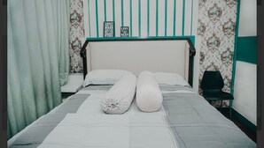 A bed with a striped headboard, a pillow, and a blanket. - Ratu homestay (Bandar Lampung)