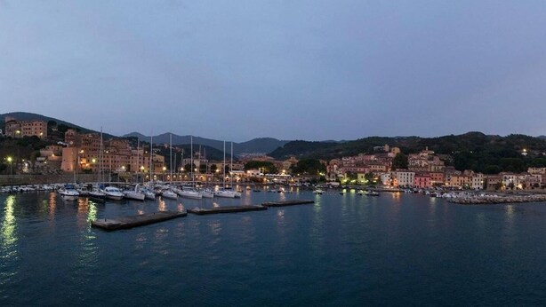 A marina with boats docked, surrounded by buildings and hills. - La casina di Silverio (Rio Marina)