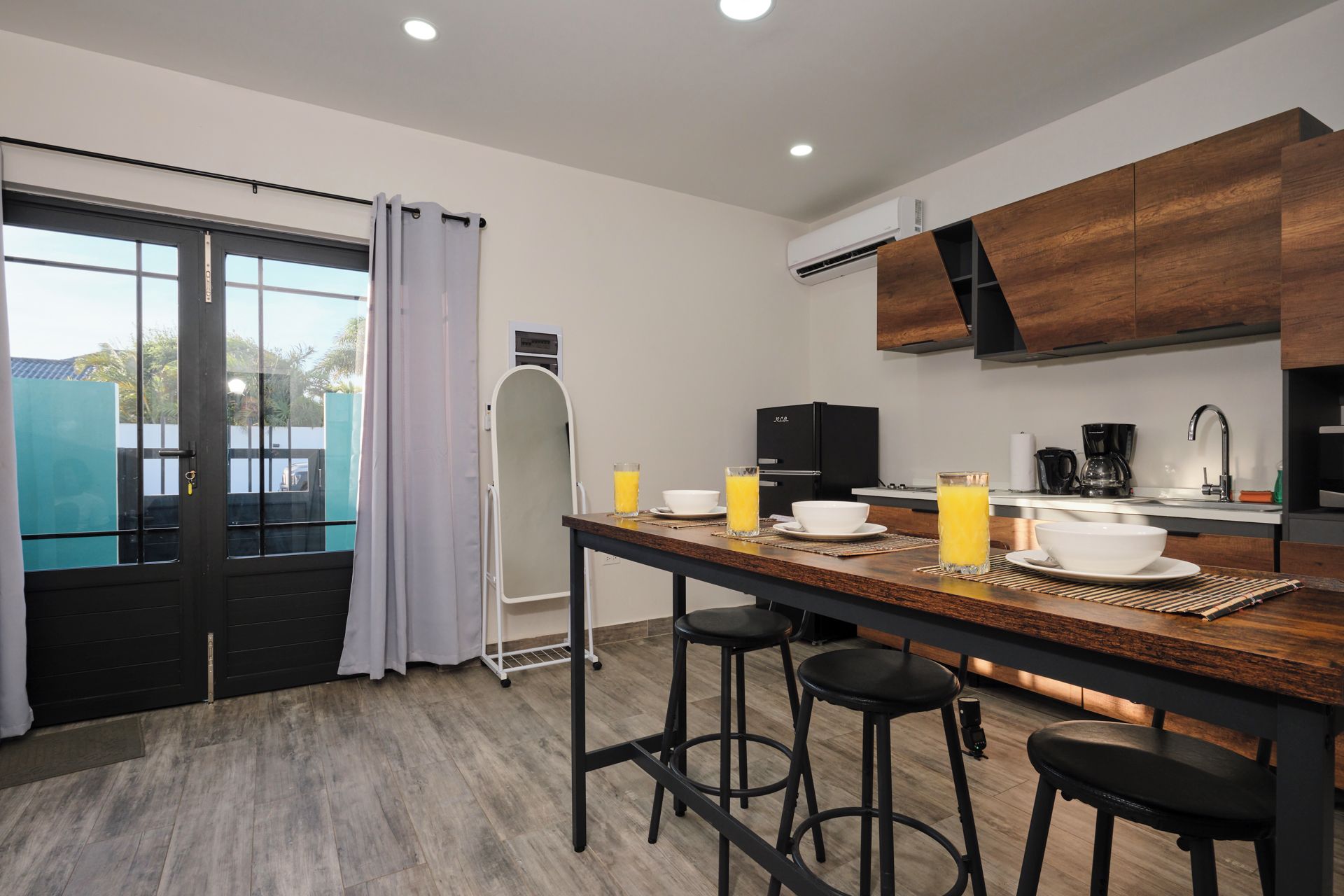 Une cuisine moderne avec un îlot central, des tabourets de bar et une table à manger.
