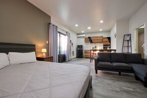 Ein Hotelzimmer mit Bett, einer Sitzecke, einer Küchenzeile und einem Essbereich.