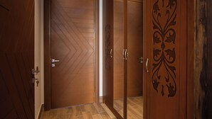 A hallway with wooden doors and a tiled floor. - Xinali Hotel Xizi  (Altiagach)