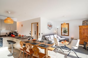 Een moderne keuken met een eethoek, een bank en een houten kast.
