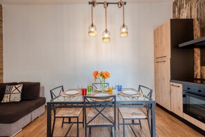 A modern kitchen with a dining table, chairs, and a hanging light fixture. - Apartment 'Stonehouse Oasis' with Private Terrace, Wi-Fi and Air Conditioning (Sant'Isidoro)