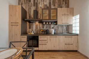 A modern kitchen with wooden cabinets, a built-in oven, and a coffee maker. - Apartment 'Stonehouse Oasis' with Private Terrace, Wi-Fi and Air Conditioning (Sant'Isidoro)