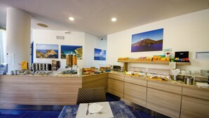 A hotel reception area with a counter, seating, and wall art. - Astro Suite (Cefalù)