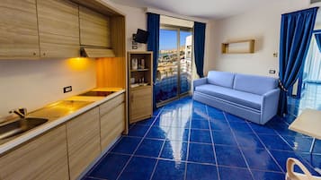 Suíte, vista parcial para o mar | Cozinha privada | Geladeira, micro-ondas, cooktop, talheres/pratos/utensílios de cozinha