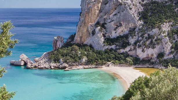 A coastal landscape with a rocky cliff, clear turquoise waters, and a sandy beach. - Residence in Budoni with 1 bedrooms sleeps 4 (Budoni)