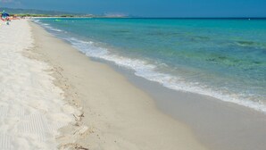 Una platja amb aigua turquesa cristal·lina i sorra blanca.