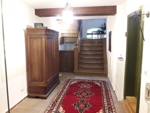 Staircase leads to a spacious hallway with a rug and a large cabinet.