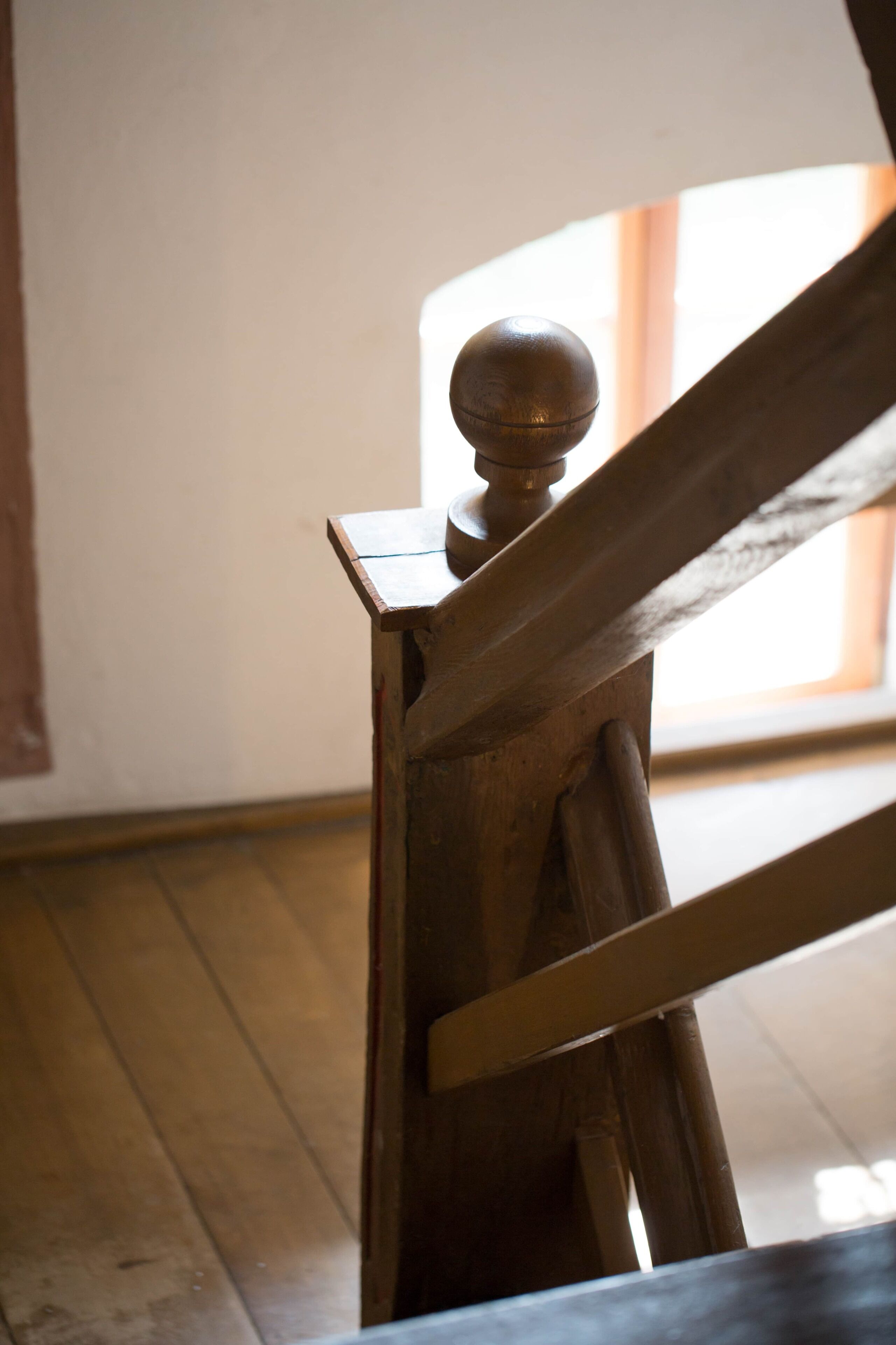 Una escalera de madera con barandilla redondeada.