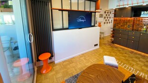 A modern kitchen with a Disney+ sign, wooden flooring, and a unique backsplash. - Absolute peace and terrace in Bastille (Paris)