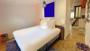 A modern bedroom with a large bed, a blue accent wall, and a wooden floor. - Absolute peace and terrace in Bastille (Paris)
